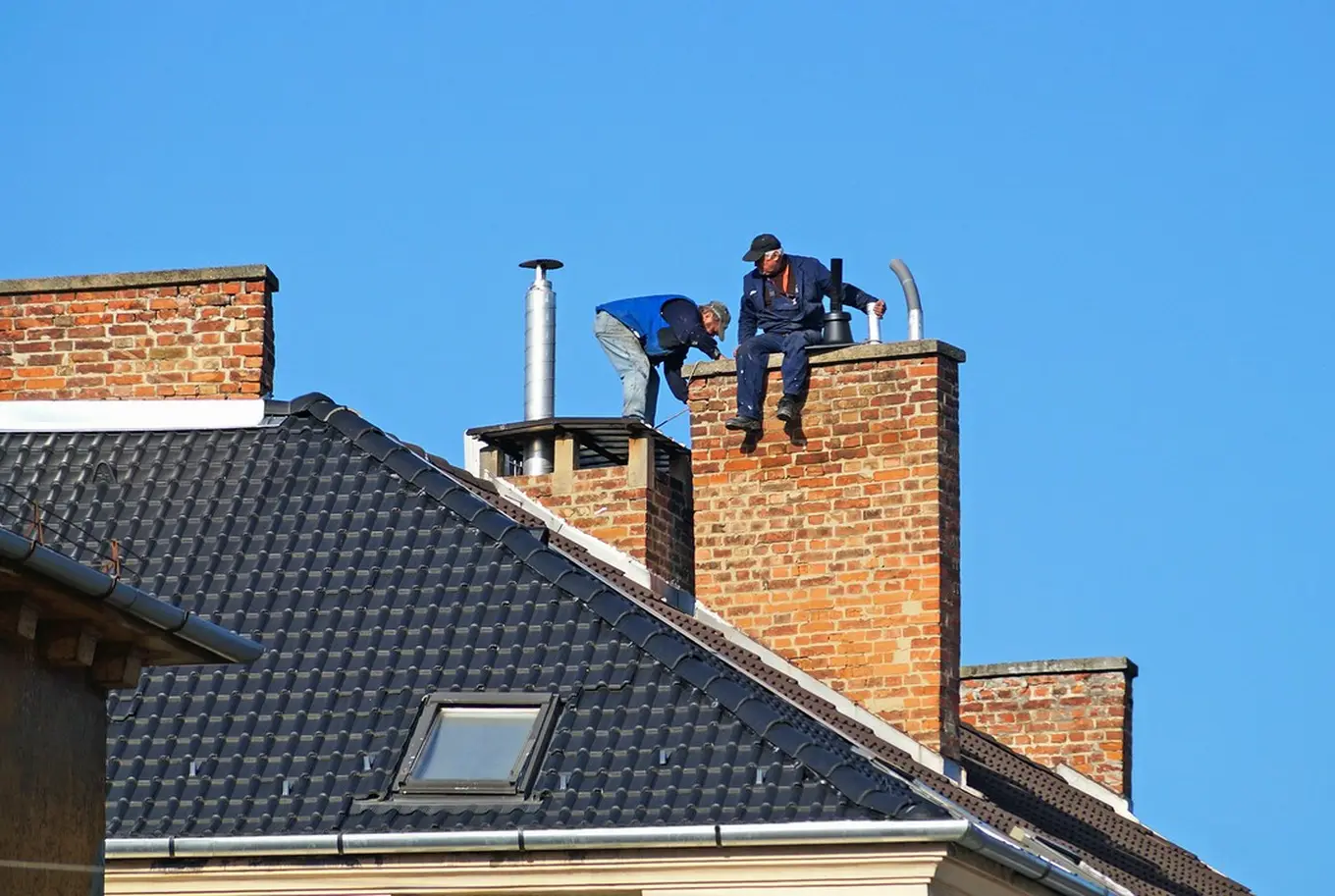 mężczyźni naprawiający komin